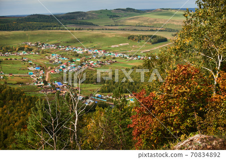 A top view of colourful forest trees and lake in the autumn season. 70834892