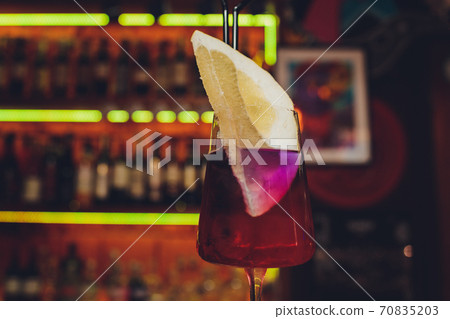 Modern Calvados Spitz Cocktail in elegant highball glass with long clear ice spear and vermouth. pomelo. 70835203
