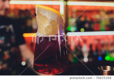 Modern Calvados Spitz Cocktail in elegant highball glass with long clear ice spear and vermouth. pomelo. 70835208