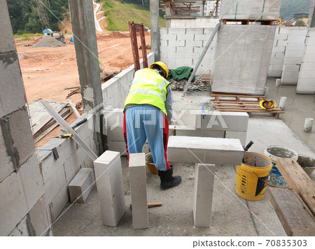 SEREMBAN, MALAYSIA -MARCH 16, 2020: Construction workers laying autoclaved aerated concrete block at the construction site. The use of this material can save time and facilitate construction work. 70835303