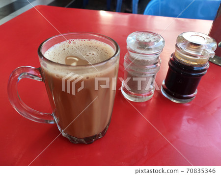 Malaysian signature drink called 'TEH TARIK'. Tea drinks mixed with creamy white creamers. Creamer base is made of palm oil base. Malaysian signature drink called 'TEH TARIK'. Tea drinks mixed with creamy white creamers. Creamer base is made of palm oil base. 70835346