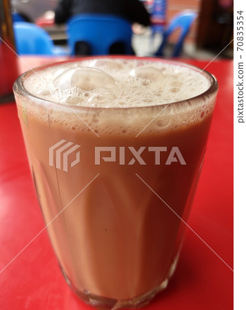Malaysian signature drink called 'TEH TARIK'. Tea drinks mixed with creamy white creamers. Creamer base is made of palm oil base. Malaysian signature drink called 'TEH TARIK'. Tea drinks mixed with creamy white creamers. Creamer base is made of palm oil base. 70835354