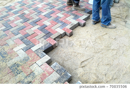 KUALA LUMPUR, MALAYSIA -AUGUST 06, 2017: Construction workers installing and arranging precast concrete pavers stone for a road at the construction site. KUALA LUMPUR, MALAYSIA -AUGUST 06, 2017: Construction workers installing and arranging precast concrete pavers stone for a road at the construction site. 70835506