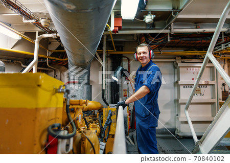 Marine engineer officer controlling vessel enginesand propulsion in engine control room ECR 70840102