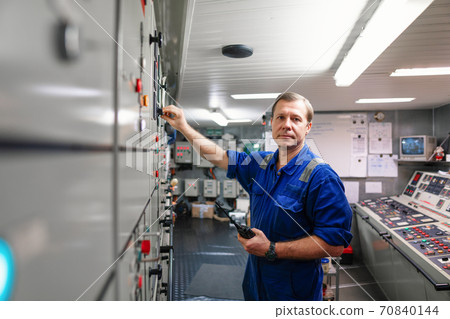Marine engineer officer controlling vessel engines and propulsion in engine control room Marine engineer officer controlling vessel engines and propulsion in engine control room 70840144