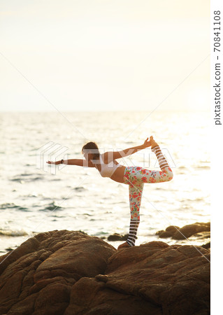 woman yoga pose on sea beach against beautiful sin rising woman yoga pose on sea beach against beautiful sin rising 70841108