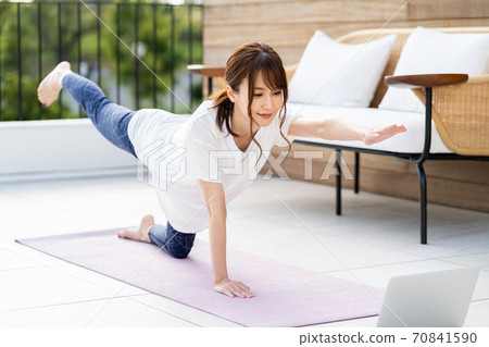 年輕女子在陽台上做在線瑜伽 70841590