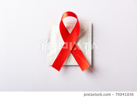 Red bow ribbon symbol HIV, AIDS cancer awareness and condom 70841836
