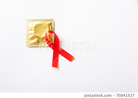 Red bow ribbon symbol HIV, AIDS cancer awareness and condom 70841837