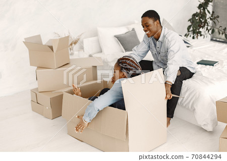 Couple with boxes moving into new home smiling 70844294