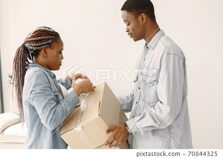 Couple with boxes moving into new home smiling Couple with boxes moving into new home smiling 70844325