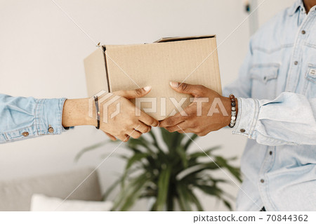 Couple with boxes moving into new home smiling Couple with boxes moving into new home smiling 70844362