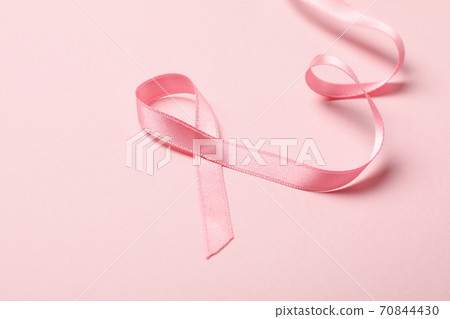Pink awareness ribbon on pink background, close up Pink awareness ribbon on pink background, close up 70844430