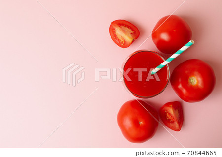 Glass with fresh tomato juice on pink background 70844665