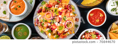 Mexican food panorama. Nachos with beef and cheese sauce and various dips, shot from above 70844670
