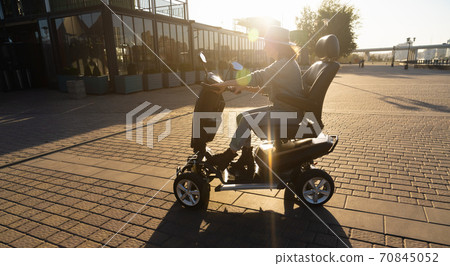 Woman riding an electric scooter  70845052