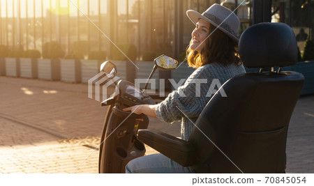 Woman riding an electric scooter  70845054