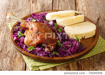 Homemade duck leg with stewed red cabbage garnish and dumplings close-up in a plate. horizontal Homemade duck leg with stewed red cabbage garnish and dumplings close-up in a plate. horizontal 70846906