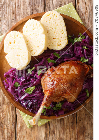 fried duck leg served with red cabbage and bread dumplings close-up in a plate. vertical top view fried duck leg served with red cabbage and bread dumplings close-up in a plate. vertical top view 70846908