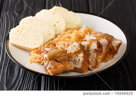 Czech cuisine Baked pork shoulder with stewed sauerkraut and bread dumplings close-up in a plate. horizontal Czech cuisine Baked pork shoulder with stewed sauerkraut and bread dumplings close-up in a plate. horizontal 70846929