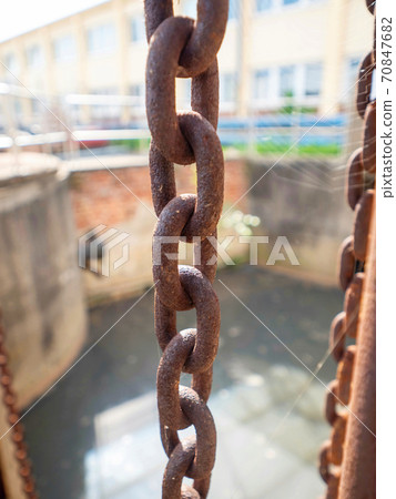 Old rusty chained and wheels. Cogs control the floodgates, 70847682