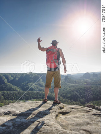 Hiker in shorts, black leather vest and leather crimson hat 70847814