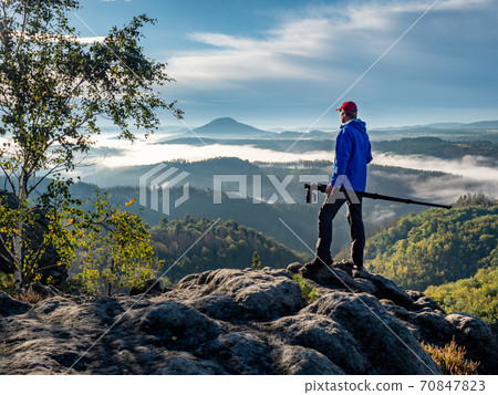 Professional on cliff. Nature photographer carry camera Professional on cliff. Nature photographer carry camera 70847823