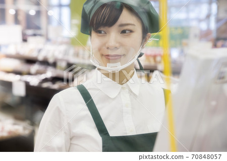 Female employee working at a supermarket cashier with infection control through the seat 70848057