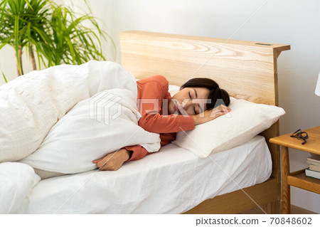 A woman sleeping in bed 70848602