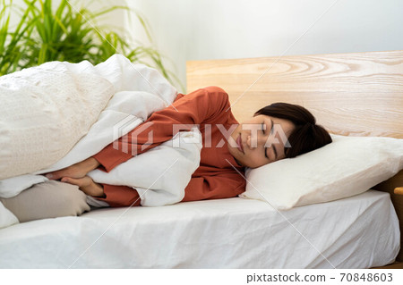 A woman sleeping in bed A woman sleeping in bed 70848603