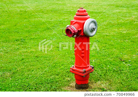 red isolated fire hydrant sits in a freshly cut grass field 70849966