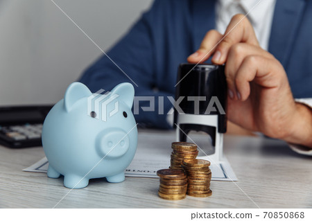 Blue piggy bank with stack of coins on desk in office. Save money and management financial concept 70850868