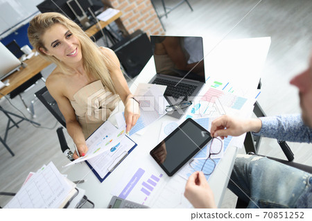 Businesswoman in office at working table communicates with a colleague. 70851252