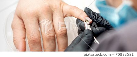 Manicure master removes cuticles by nail clipper 70852581
