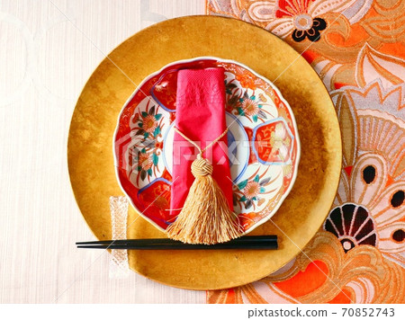 Table coordination of red Imari plate and orange sack belt (center) 70852743
