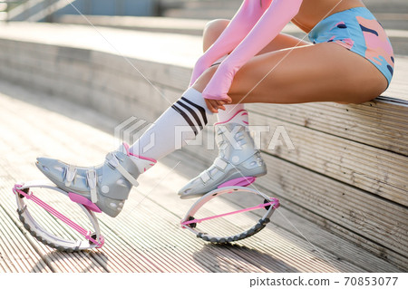 Close ups womans feet with kangoo jumps. Outdoor city sport and training. 70853077