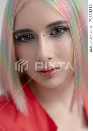 Portrait of a young beautiful informal blonde girl with dyed hair. Red jacket suit on the naked body. Studio photoshoot on a white background. Portrait of a young beautiful informal blonde girl with dyed hair. Red jacket suit on the naked body. Studio photoshoot on a white background. 70853216