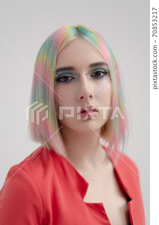 Portrait of a young beautiful informal blonde girl with dyed hair. Red jacket suit on the naked body. Studio photoshoot on a white background. Portrait of a young beautiful informal blonde girl with dyed hair. Red jacket suit on the naked body. Studio photoshoot on a white background. 70853217