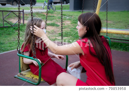 Child and mom in medical mask on a walk. Family wearing face mask 70853958