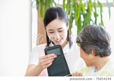高級婦女和護理人員測量血壓的護理人員 高級婦女和護理人員測量血壓的護理人員 70854244