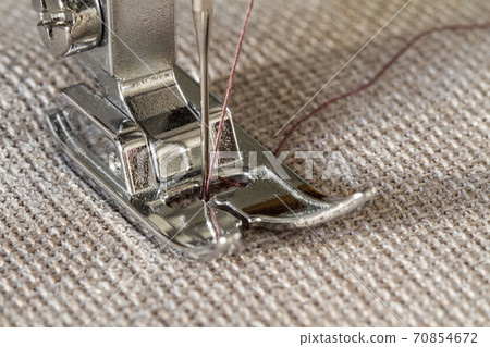 Closeup of sewing machine working part with beige fabric Closeup of sewing machine working part with beige fabric 70854672