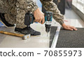 drill in a man's hand close-up on a light background 70855973