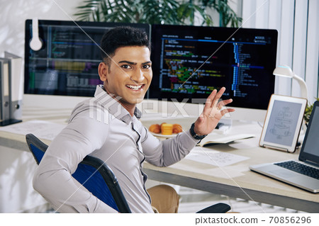 Software developer waving at camera 70856296