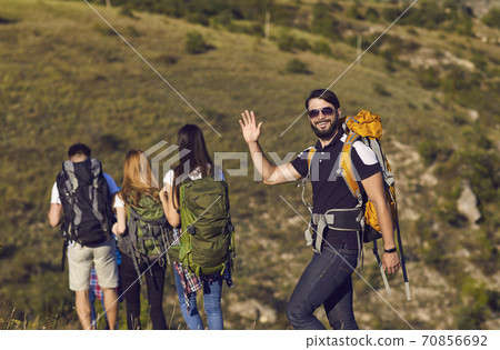 A group of hikers with backpacks are walking along the hill in the mountains in nature. A group of hikers with backpacks are walking along the hill in the mountains in nature. 70856692