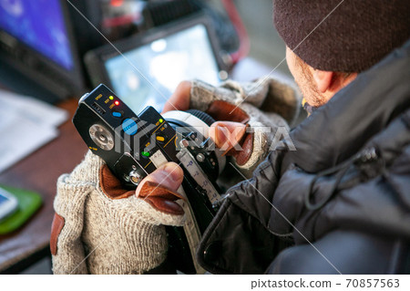Male hands hold the wireless follow focus system during the filming process. Male hands hold the wireless follow focus system during the filming process. 70857563