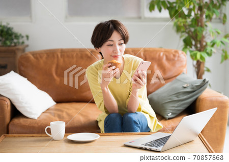 一個女人在工作之間吃糖果 一個女人在工作之間吃糖果 70857868