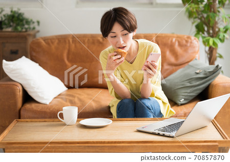 一個女人在工作之間吃糖果 70857870