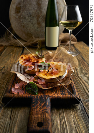 Baked Camembert cheese with toasted bread on wooden board 70857972