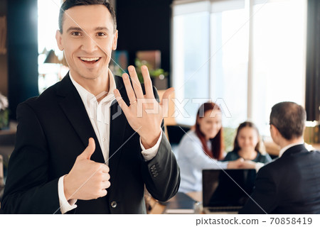 Man shows ring on his finger and show thumb up.  70858419