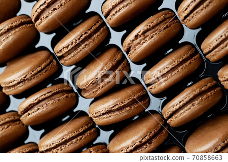 Chocolate-flavored French macaroons are in the bakery. Chocolate-flavored French macaroons are in the bakery. 70858663